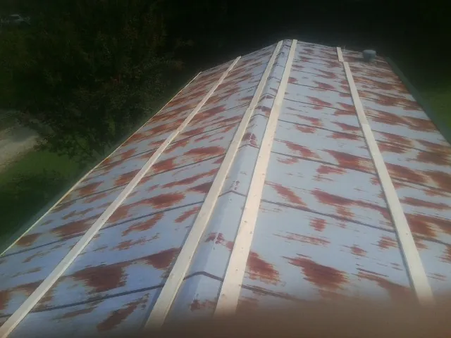 Rusted metal roof panels with new wood purlins before replacement — Storm Damage Roof Repair in Cheraw by Roofing Brothers