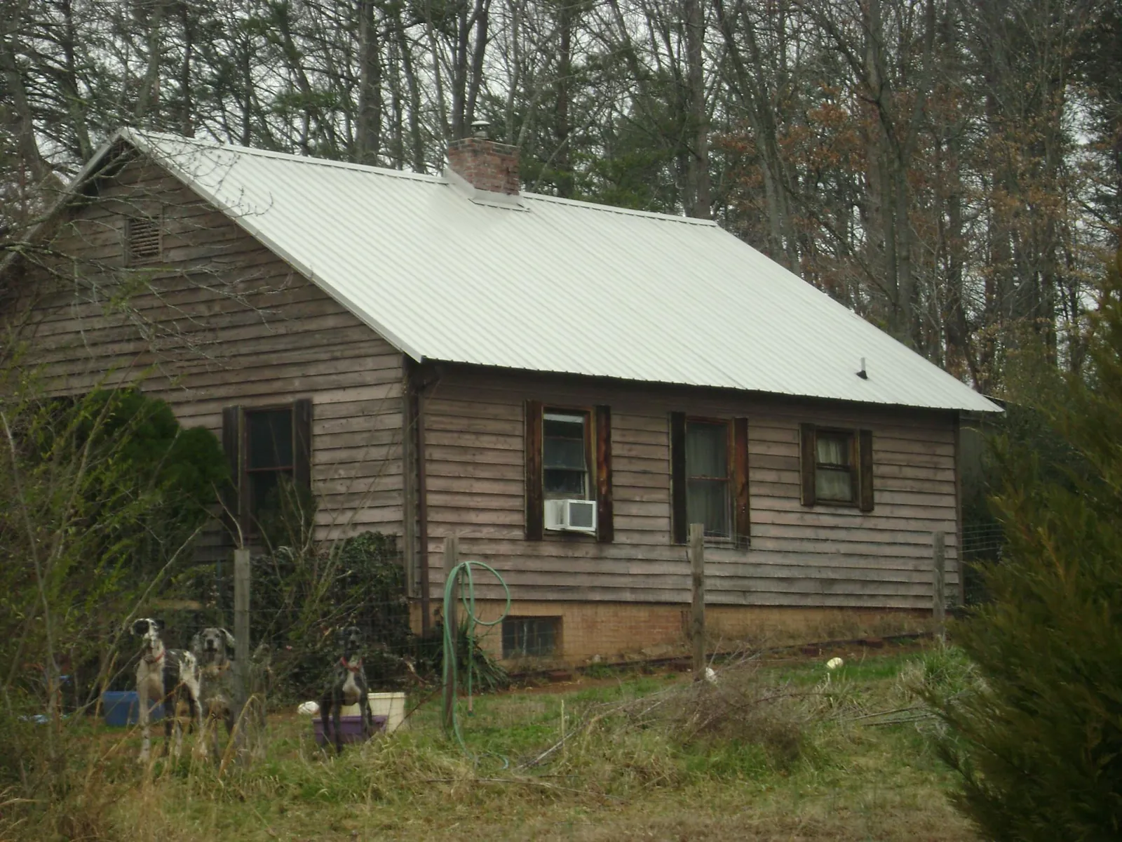 White metal roof on an old wood sided farmhouse, from a Metal Roof Installation job in Cheraw